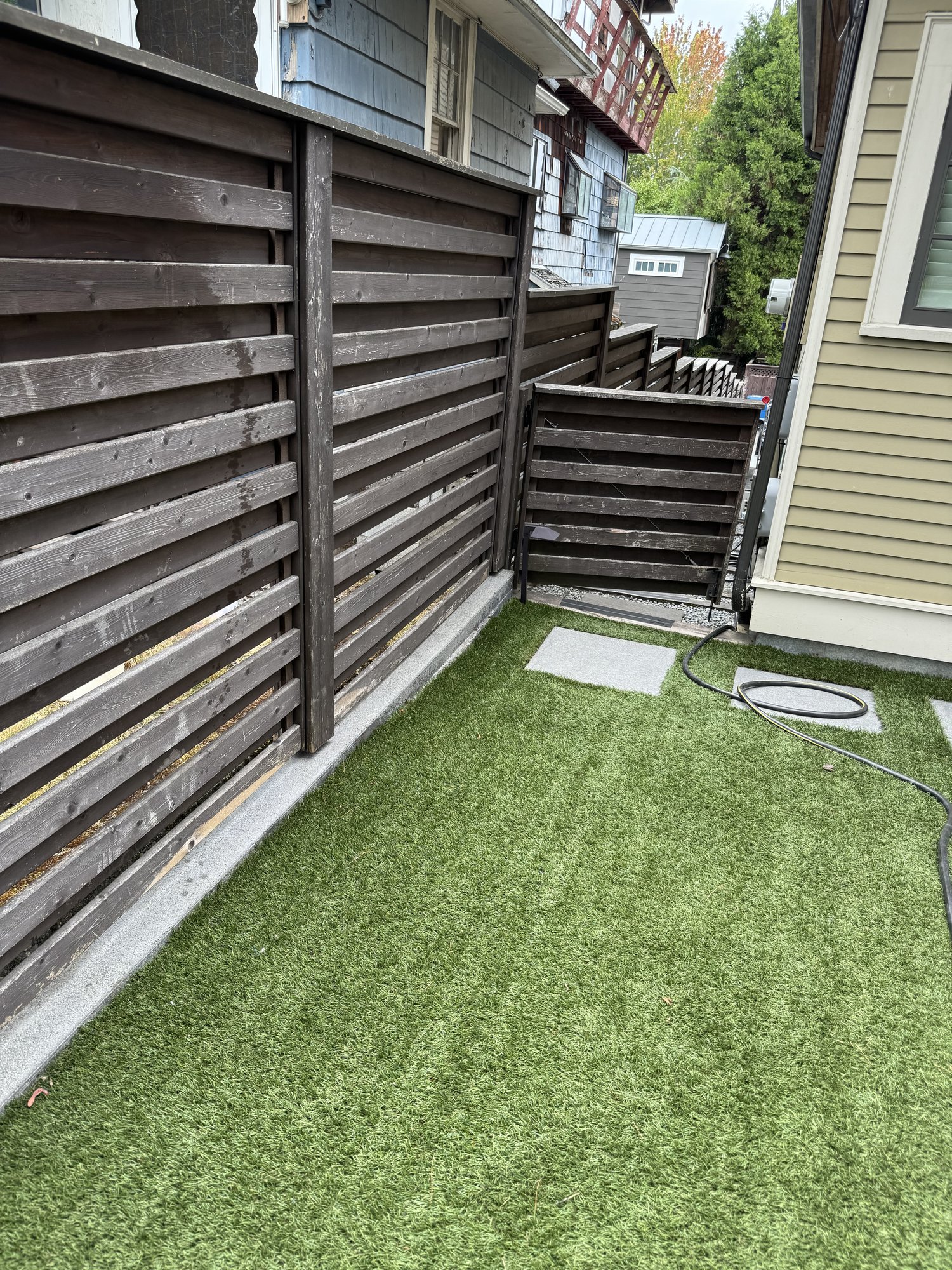 Finished privacy fence beside a turf yard