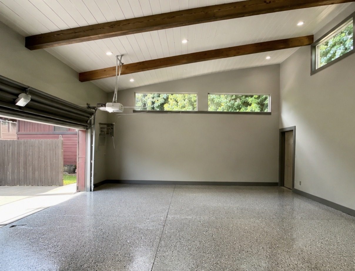 Finished garage interior with polished floor and exposed beams