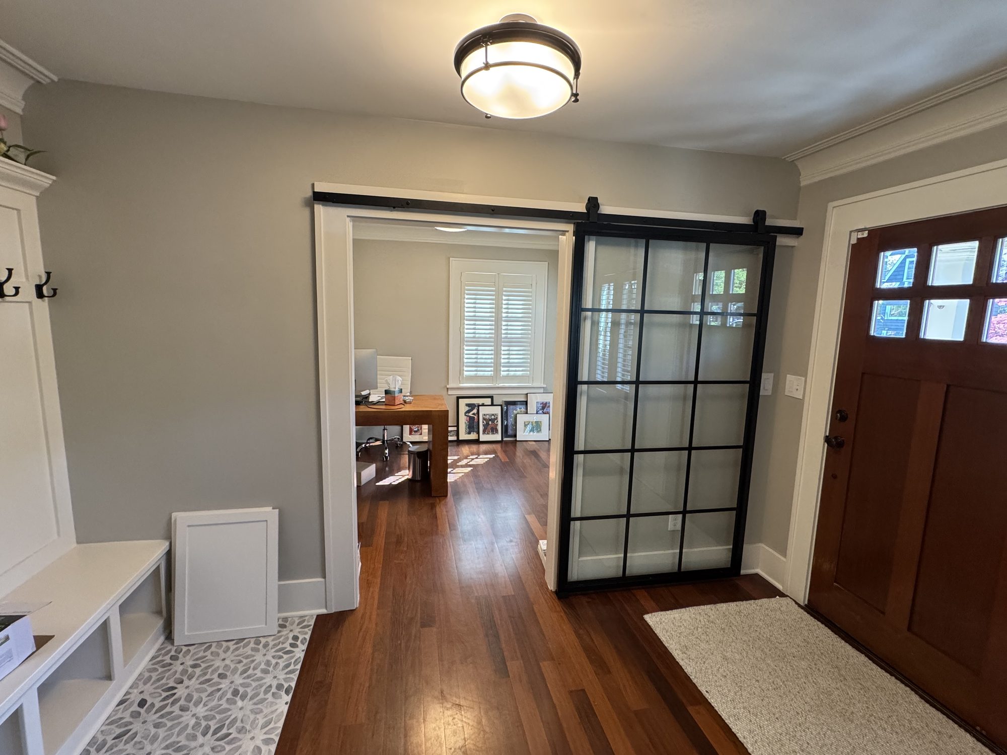 Mudroom entry with tile inset and sliding glass barn door
