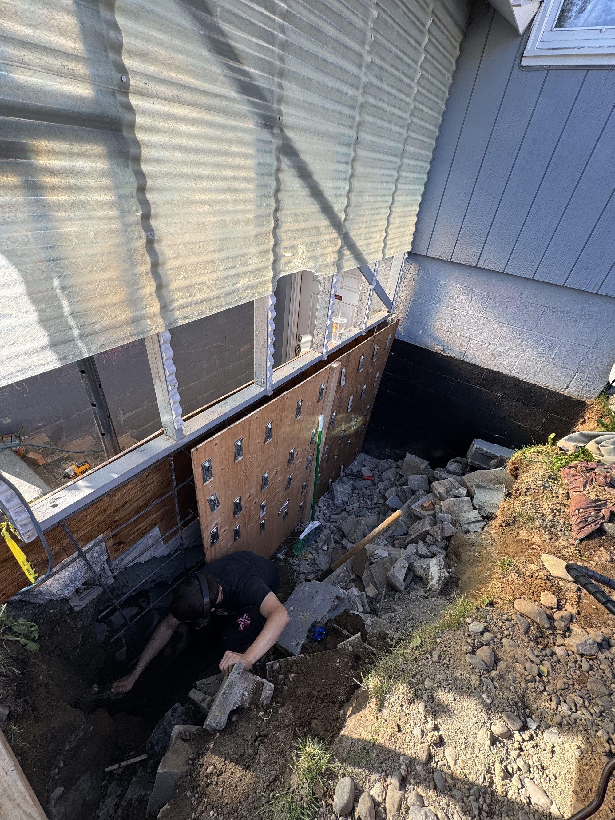 Top Notch crew member setting rebar in a retaining wall excavation