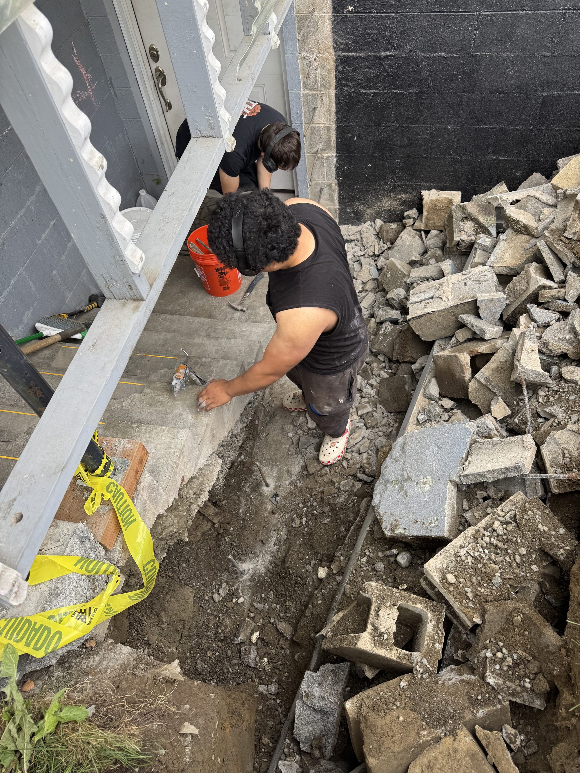 Crew working in a shored excavation during a retaining wall rebuild