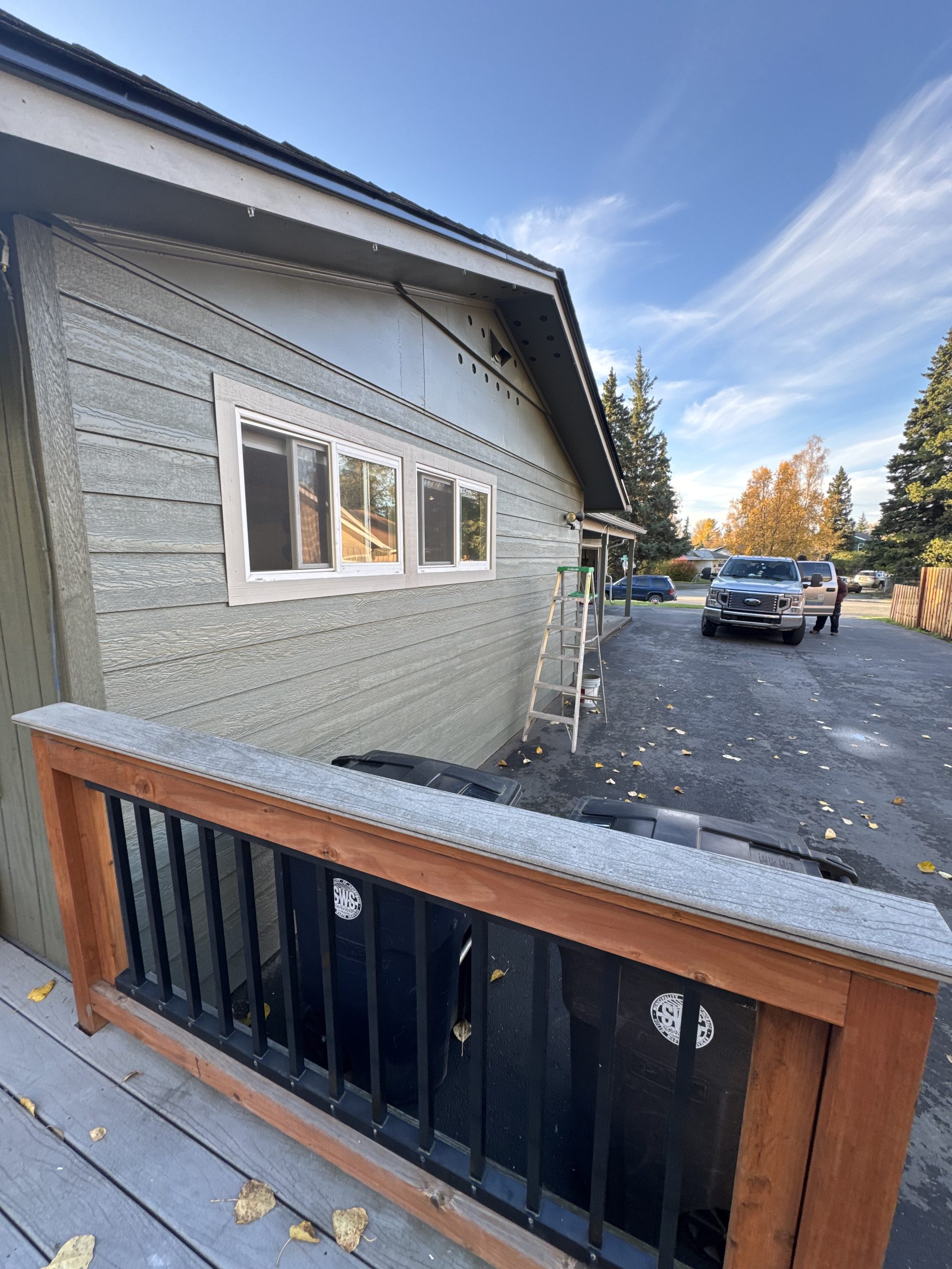 Finished exterior with new siding, windows, and deck railing