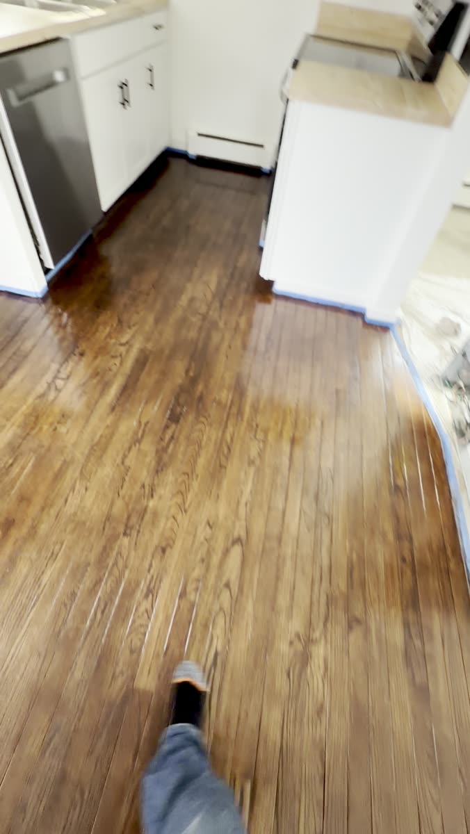 Hardwood floor with finish going down beside the kitchen